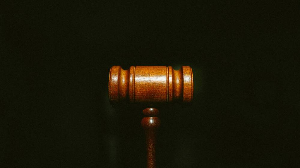 A wooden gavel resting on a fine notice highlighting jury duty consequences