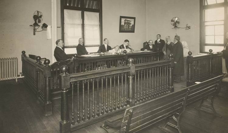 Jurors seated around a conference table reviewing trial notes