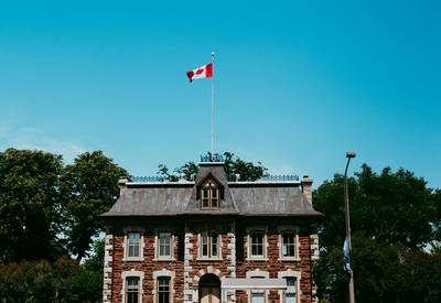 A stately Ontario courthouse exterior with the Canadian flag flying