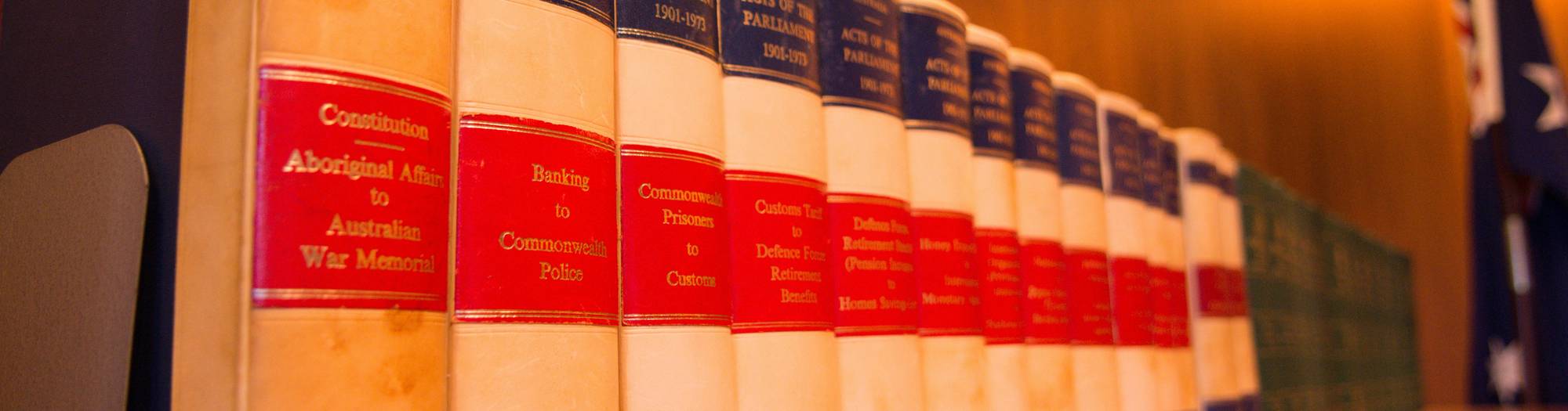 Dark blue toned image of a gavel resting on law books to convey legal consequences